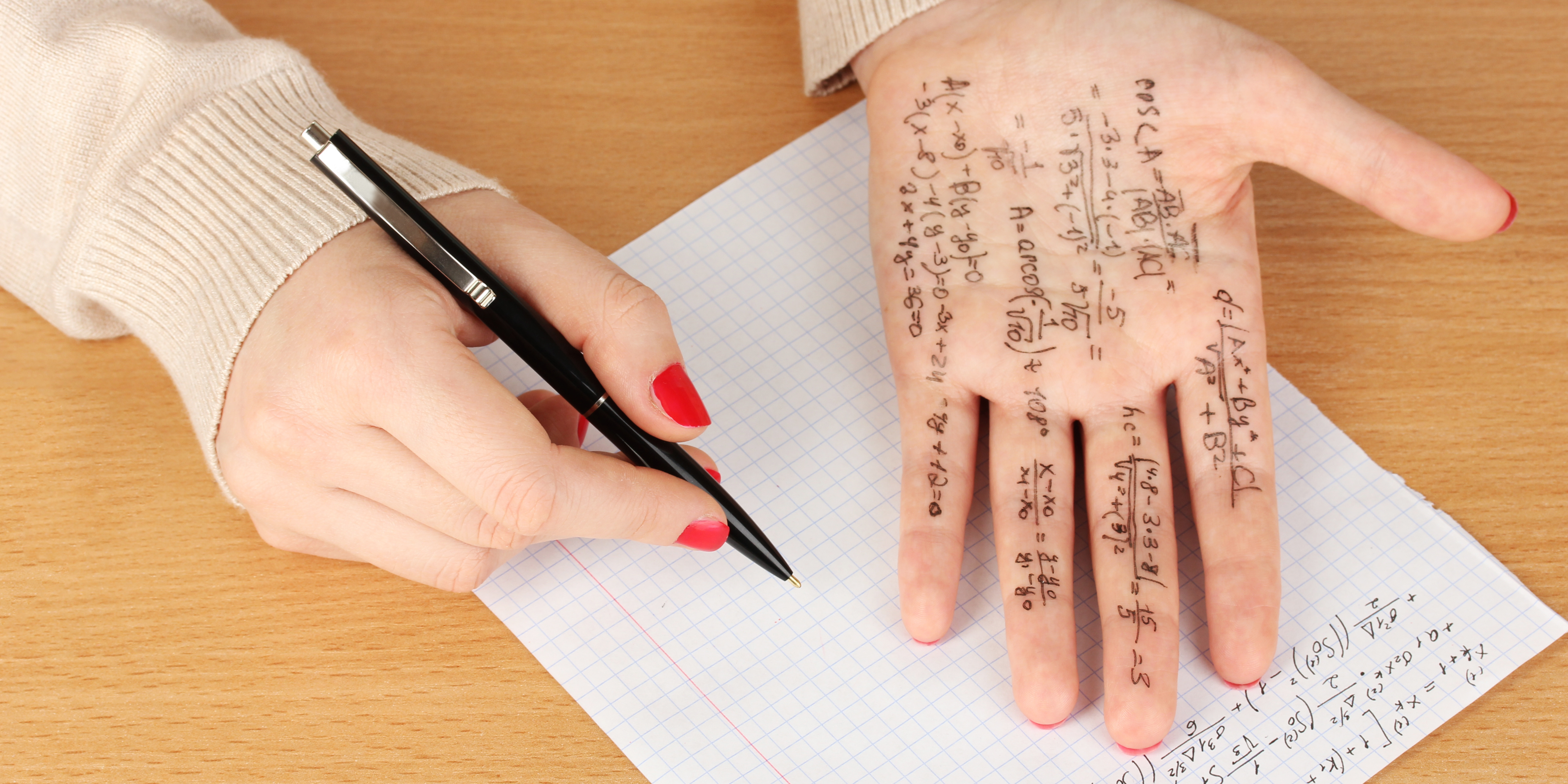 Hand with pen and hand with math formulas.