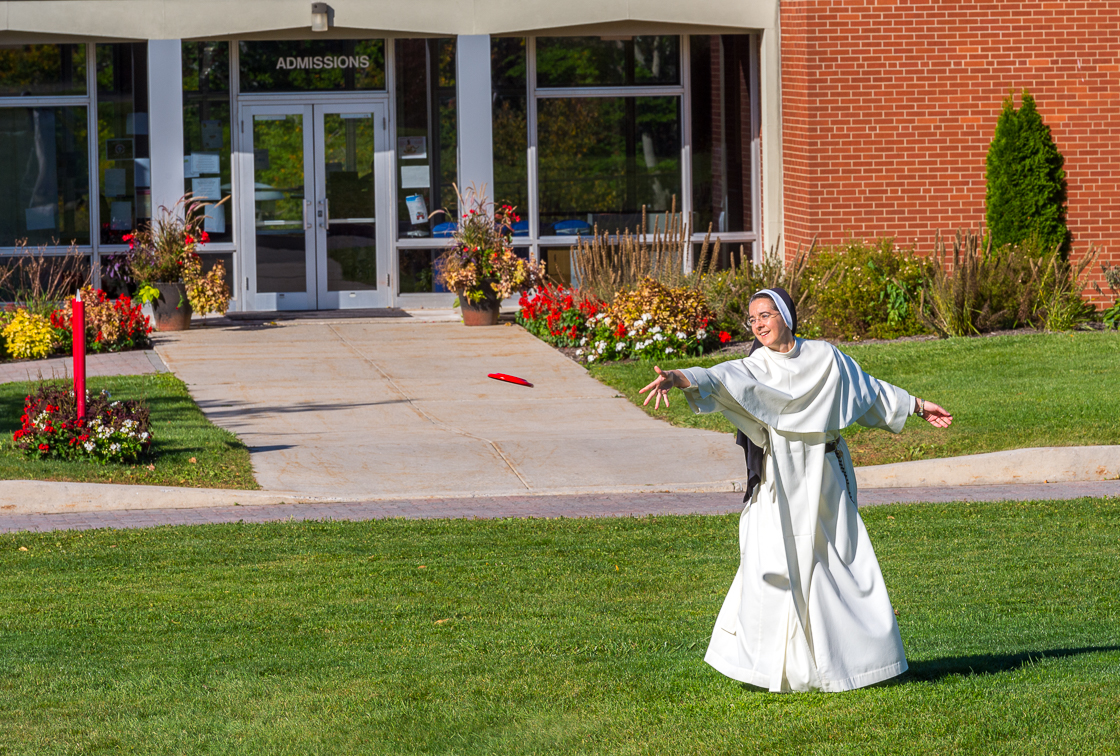 Person throwing disc at university campus.